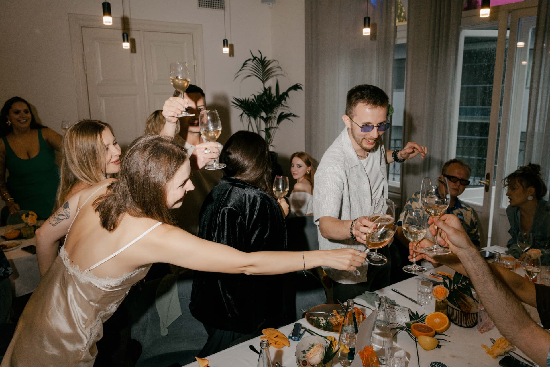 Guests toasting with wine glasses at a dinner party